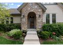 Close-up of a welcoming front entrance featuring stone archway, decorative plants, and a well-maintained pathway at 652 Ulster Way, Denver, CO 80230