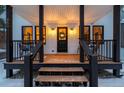 Inviting front porch with black railings and a wreath on the door at 950 Tenderfoot Dr, Larkspur, CO 80118
