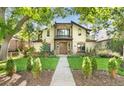 Charming two-story home with stone accents, landscaped yard, and a walkway leading to the front entrance at 718 Locust St, Denver, CO 80220
