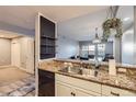 A kitchen with a stainless steel sink, granite countertops, white cabinets, and wood floors at 975 N Lincoln St # 4I, Denver, CO 80203