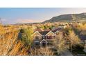 Beautiful sunset aerial view of the home featuring mature trees, and mountain views at 17294 W 60Th Ct, Arvada, CO 80403