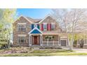 Charming two-story home featuring a lovely front porch, brick facade, and colorful details at 17294 W 60Th Ct, Arvada, CO 80403