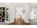 Bright hallway with hardwood floors, white walls and trim, and decorative archways at 17294 W 60Th Ct, Arvada, CO 80403
