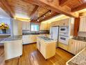 Spacious kitchen featuring wood floors, granite countertops, a central island, and modern appliances perfect for culinary enthusiasts at 2418 W Euclid Ave, Littleton, CO 80120