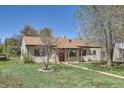 Quaint single-story house with a red front door and a well-kept lawn, surrounded by trees at 2865 S Fairfax St, Denver, CO 80222