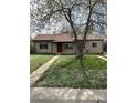 Charming single-story home featuring a well-maintained lawn, mature shade tree and a inviting red front door at 2865 S Fairfax St, Denver, CO 80222