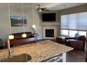 Open-concept living room with fireplace and kitchen island at 9557 W San Juan Cir # 207, Littleton, CO 80128