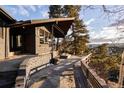 Outdoor patio with stone flooring, wood bench, and scenic views, perfect for relaxation and entertaining at 22598 Westview Ave, Golden, CO 80401