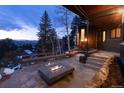 Outdoor patio featuring a modern fire pit and seating, with stunning twilight mountain views at 22598 Westview Ave, Golden, CO 80401