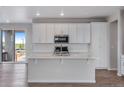 Modern kitchen with stainless steel appliances, subway tile backsplash, and center island at 24801 E 33Rd Dr, Aurora, CO 80019