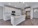 Bright kitchen boasts white cabinets, a large center island, and stainless steel appliances at 24801 E 33Rd Dr, Aurora, CO 80019