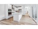 Bright, modern kitchen with stainless steel appliances, island, and sleek white cabinetry at 2031 Generations Aly, Brighton, CO 80601