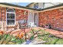 Inviting front porch with brick facade, seating and a beautiful garden at 8561 E Grand Ave, Denver, CO 80237