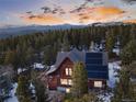 Mountain home nestled among lush trees featuring solar panels, mountain views in the background, and a private setting at 439 Ronnie Rd, Golden, CO 80403