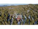 Scenic aerial view of a charming cabin nestled in a dense forest, offering a serene and private retreat at 439 Ronnie Rd, Golden, CO 80403