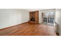 Living room with hardwood floors, brick fireplace, and sliding glass door to patio at 1350 Josephine St # 208, Denver, CO 80206