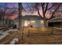 Charming single-story home with a cozy front yard and a rustic wooden fence at sunset at 1010 Emporia St, Aurora, CO 80010