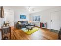 Bright living room with hardwood floors, a comfortable gray sectional, and a large window at 1010 Emporia St, Aurora, CO 80010