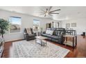 Open-concept living room featuring hardwood floors, ceiling fan and lots of natural light at 879 Canary Ln, Brighton, CO 80601