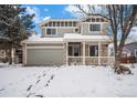 Two-story house with gray siding, stone accents, and a covered porch sits on a snow-covered lot at 5229 Nighthawk Pkwy, Brighton, CO 80601