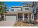 Charming two-story home featuring a welcoming porch and an attached two-car garage at 5229 Nighthawk Pkwy, Brighton, CO 80601