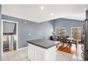Bright kitchen with white cabinets, island, stainless steel appliances, and an adjacent dining area at 5229 Nighthawk Pkwy, Brighton, CO 80601