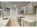 Well-equipped kitchen with stainless steel appliances and white countertops, perfect for cooking at 8637 Middle Fork St, Littleton, CO 80125