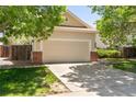 Attached two-car garage with brick accents and long driveway nestled between mature green trees at 12666 Davis St, Broomfield, CO 80020
