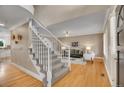 Inviting foyer leading to a living room with hardwood floors, stairs, and an open floor plan at 5668 S Rifle Ct, Centennial, CO 80015