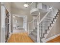 Bright foyer featuring hardwood floors, a staircase with white railings, and an open view to the office space at 5668 S Rifle Ct, Centennial, CO 80015
