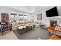 Bright living room featuring large windows with scenic views, stylish sectional, and modern fireplace at 8109 Mount Ouray Rd, Littleton, CO 80125