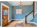 Bright entryway with hardwood floors, chandelier, wooden door, and stairway with white banister at 1006 S Emerson St, Denver, CO 80209