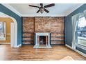 Living room with hardwood floors, brick fireplace, built-in shelves, and large windows for natural light at 1006 S Emerson St, Denver, CO 80209