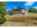 This home features a white fenced in yard, a stone and wood facade, and a raised back patio at 10731 Featherwalk Ln, Highlands Ranch, CO 80126
