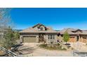 Charming stone home with well-manicured front yard and a curved driveway at 10731 Featherwalk Ln, Highlands Ranch, CO 80126