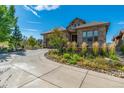 This home features a stone and tile exterior, two car garage, and beautiful garden landscaping at 10731 Featherwalk Ln, Highlands Ranch, CO 80126