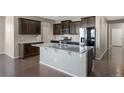 Modern kitchen with dark cabinets, stainless steel appliances, and granite countertops at 12210 Pine Post Dr, Parker, CO 80138