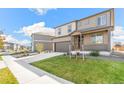 Beautiful two-story home with a covered porch, two car garage and a green yard at 4338 Cattle Cross Trl, Castle Rock, CO 80104
