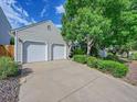 View of home showing a two-car garage, beautiful yard, and charming exterior at 5319 E Davies Dr, Centennial, CO 80122