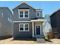Charming two-story home with gray siding, brick accents, and a covered front porch at 3297 N Duquesne Way, Aurora, CO 80019