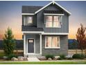 Charming two-story home with gray siding, brick accents and professional landscaping at 3297 N Duquesne Way, Aurora, CO 80019