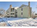 Green two-story building exterior with snowy yard at 14110 E Temple Dr # X02, Aurora, CO 80015