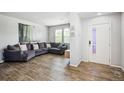 Cozy living room featuring a large sectional couch, wood floors, and natural light at 16019 E Elk Dr, Denver, CO 80239