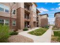 Well-maintained condo building with attractive landscaping, pathways, and private outdoor spaces at 15345 W 64Th Ln # 107, Arvada, CO 80007