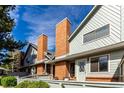 Beautiful exterior shows the architecture and brick chimney accents under a blue sky at 3049 E Long S Cir, Centennial, CO 80122