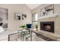 Living room with a decorative fireplace, neutral walls, and modern glass table at 3049 E Long S Cir, Centennial, CO 80122