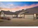 Beautiful single story home featuring a large driveway and attached garages at dusk at 23753 E Kettle Pl, Aurora, CO 80016