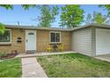 Inviting brick home featuring a well-kept front yard, a pathway to the front door, and quaint seating at 5820 S Cherokee St, Littleton, CO 80120