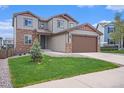 Two-story home featuring stone accents, a well-manicured lawn, and a large two car garage at 1018 Mcmurdo Cir, Castle Rock, CO 80108