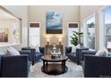 Spacious living room with four blue armchairs, a coffee table, and large windows at 10750 Fairbairn Way, Highlands Ranch, CO 80130